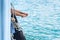 Girl legs hang off edge Passenger boat in ocean.