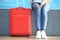 Girl legs and red suitcase close-up