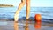 Girl legs step over washed up buoy and go into sea closeup