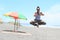 Girl levitating in yoga pose on beach