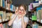 GIRL IN THE LIBRARY BETWEEN racks with books, a beautiful blonde