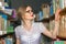 GIRL IN THE LIBRARY BETWEEN racks with books looking beautiful b