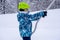 A girl lifting on the ski drag lift rope in blue sport outfit on the ski resort mountain do a ski lesson during a