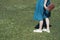 Girl in a light dress walking on the meadow. Walk on the lawn. Lower body in frame