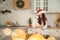 A girl in a light Scandinavian kitchen prepares Christmas dinner and lunch. Young woman and gingerbread close-up and copy space
