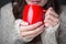 Girl in a light sweater holding red cup of coffee