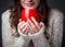 Girl in a light sweater holding a red cup of coffee