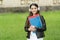 Girl listening audio carry textbooks on way to school, language lessons concept