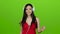 Girl listens to cheerful music through headphones and dances. Green screen. Slow motion