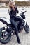 girl with long blond hair in leather jacket,posing on motorbike