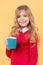 Girl with long blond hair in red sweater hold mug