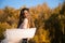 girl with long dark hair wraps herself in a flying chiffon fabric, leaning on the railing of a bridge on a clear cloudless day