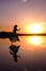 girl in a long dress on a salty pink lake against the background of a bright sunset. dark silhouette in flight