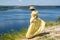 A girl in a long dress standing on a cliff by the bay