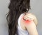 A girl with long hair clings to a sore shoulder medical