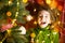 A girl with long hair and garlands lies on a red plaid under a Christmas tree with toys in a warm knitted sweater. Christmas, New