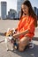 girl with long hair and orange comfy clothes with two small adorable dogs Jack Russell terriers