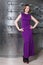 A girl in a long purple dress in clothes shop