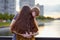 Girl with long thick dark hear embracing redhead boy on bridge, teen love at the sunset