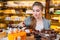 Girl looking at the bakery window with different pieces of cakes.