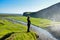 Girl looking at famous Skogafoss Waterfall, Iceland