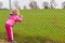 Girl looking through fence