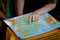 the girl is looking at a geographical atlas. geographical map in the hands of a schoolboy girl.