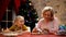 Girl looking granny decorating traditional Xmas cookies, holiday preparations