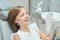 Girl looking at mirror on her teeth with orthodontic braces