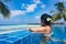 Girl looking at the ocean while sitting by the pool