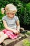 Girl looking at plants grass through magnifying glass.