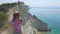 Girl looking at the sheer white cliffs of Cape Drastis near Peroulades