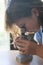 Girl looking at a specimen through a school microscope on a study table