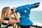 Girl looking through a stationary paid telescope