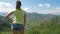 The girl looks at the amazing mountain landscape. Girl in short jeans blue shorts. Summer fresh style.