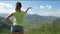 The girl looks at the amazing mountain landscape. woman pointing into the distance. Girl in short jeans blue shorts