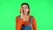 Girl looks around, covers her mouth with her hand and whispers the secret and making a hush gesture. Green screen