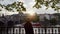 Girl looks at beautiful sunset from promenade. Red motor ship floats along river. Silhouette of girl in evening light