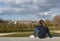 The girl looks into the distance. Heavenly landscape of storm clouds. Houses and energy windmill away