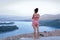 A girl looks from a height at the river.A young girl stands near a cliff, and looks down.View from the height of the river