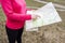 Girl looks at map in hike in an open area. Orienteering in the wild. Hiking through the mountains and forests. Active rest.