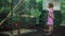 A girl looks at a monkey in a cage at the zoo