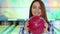 Girl looks out from behind the bowling ball