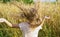 Girl with loose blond hair on the background of a wheat field on a summer farm. Summer, sun and warmth concept