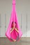 Girl lotus pose aerial antigravity yoga. Woman sits in hammock