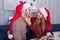 A girl lovingly looks at the guy, touching his face , the guy smiles back. Christmas atmosphere. Indoors.