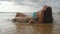 girl lying on the beach in the waves. Beautiful young woman relaxing on golden sand on sea shore during summer