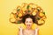 Girl lying with orange fruits in long hair screams in despair, young shocked woman with citrus slices and leaves, emotion splash