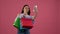 Girl make selfies with colorful packages. Pink background. Slow motion