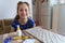 The girl makes crafts, glues cardboard, sits in the home kitchen